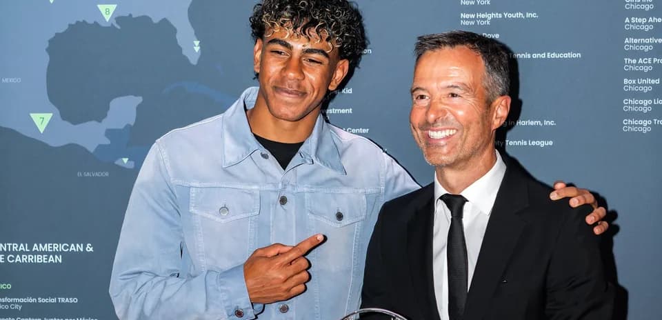 Dos hombres posando con un trofeo en evento