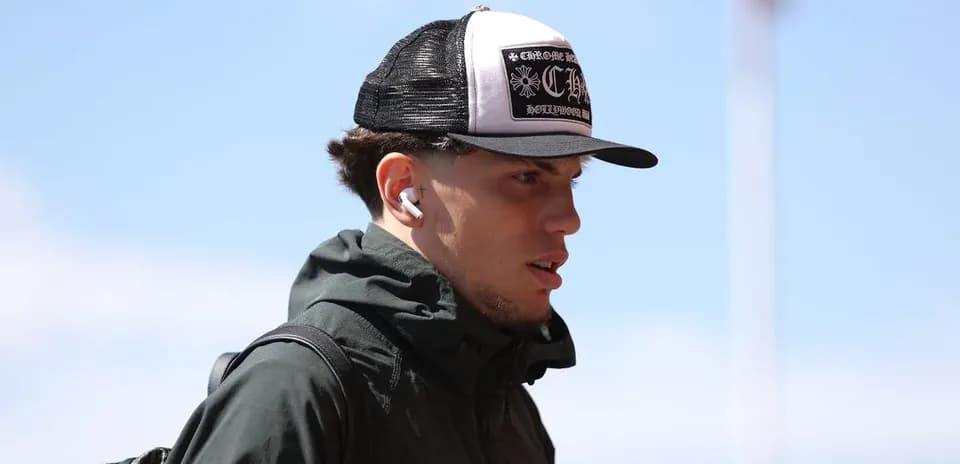 Jugador caminando con gorra y auriculares blancos
