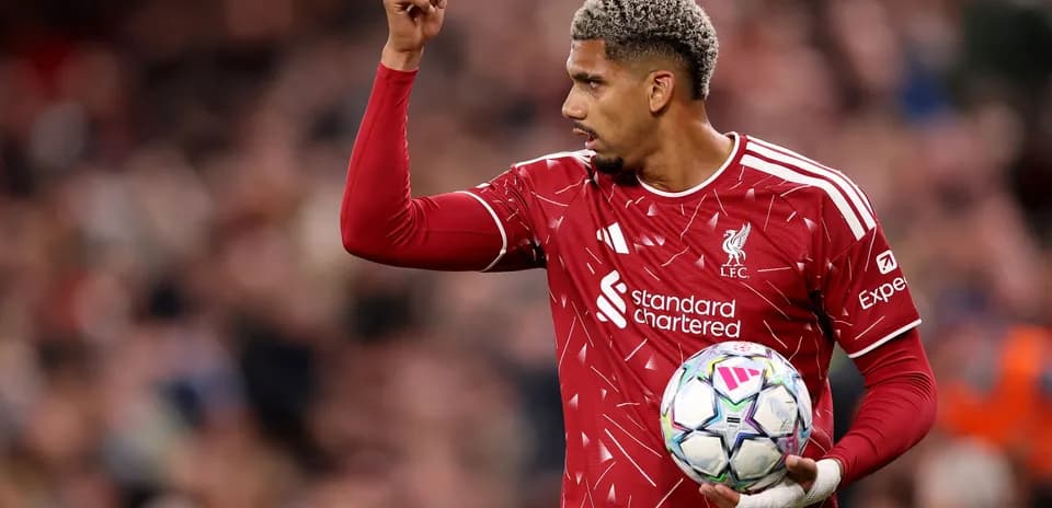 Jugador de Liverpool sosteniendo el balón en el campo