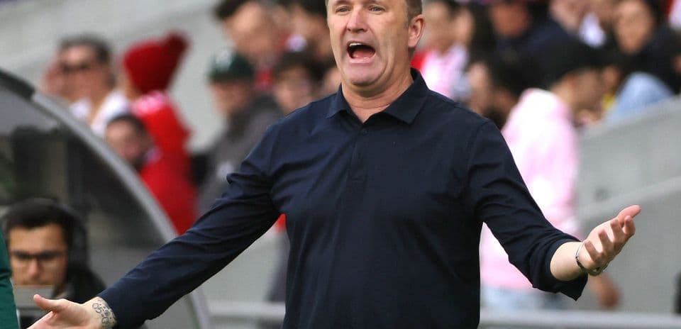 Entrenador gesticulando durante un partido de fútbol