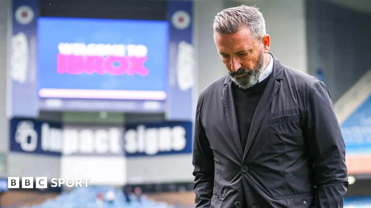 Entrenador caminando en Ibrox Stadium, mirando hacia abajo