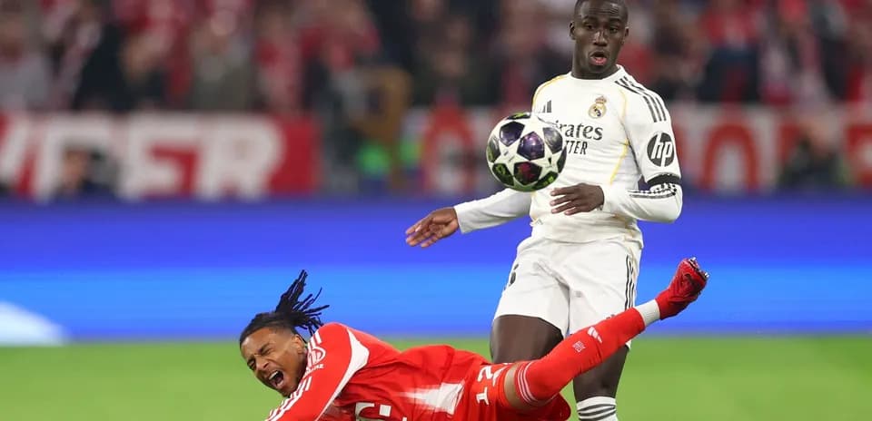 Jugador de Real Madrid controlando el balón mientras rival cae