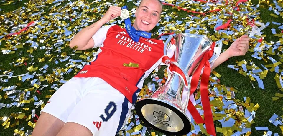 Jugadora de Arsenal con trofeo y medalla en celebración