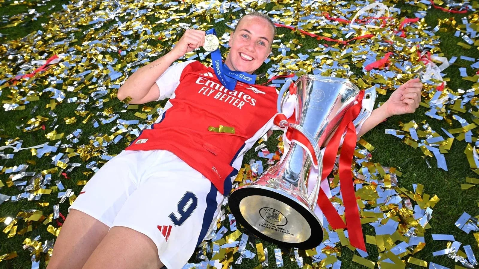 Jugadora de Arsenal con trofeo y medalla en celebración