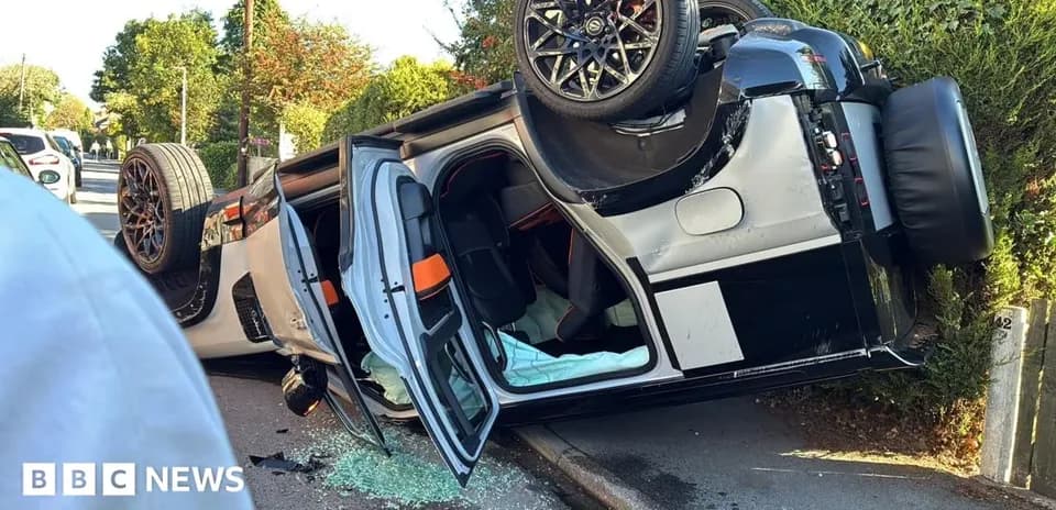 Coche volcado con puertas abiertas y cristales rotos