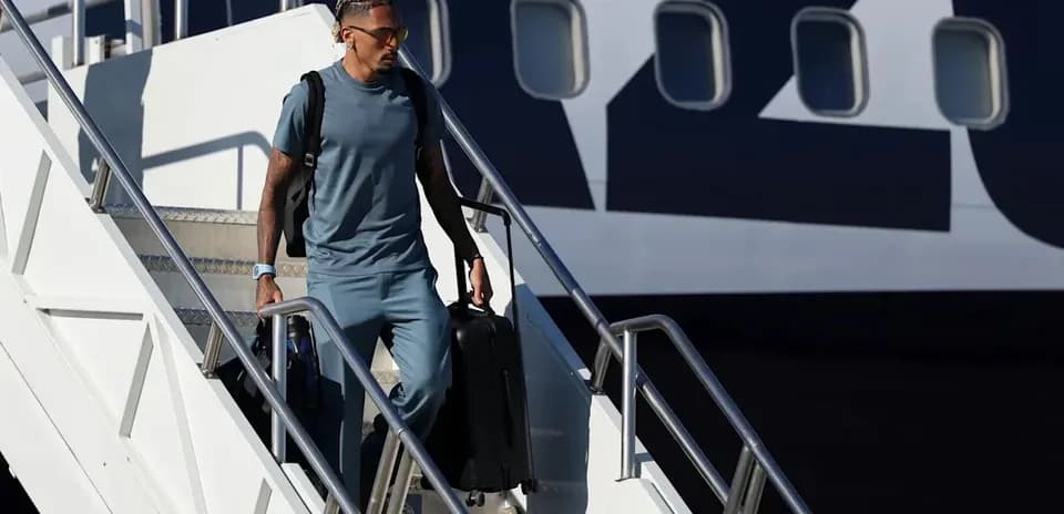 Jugador descendiendo del avión con maleta