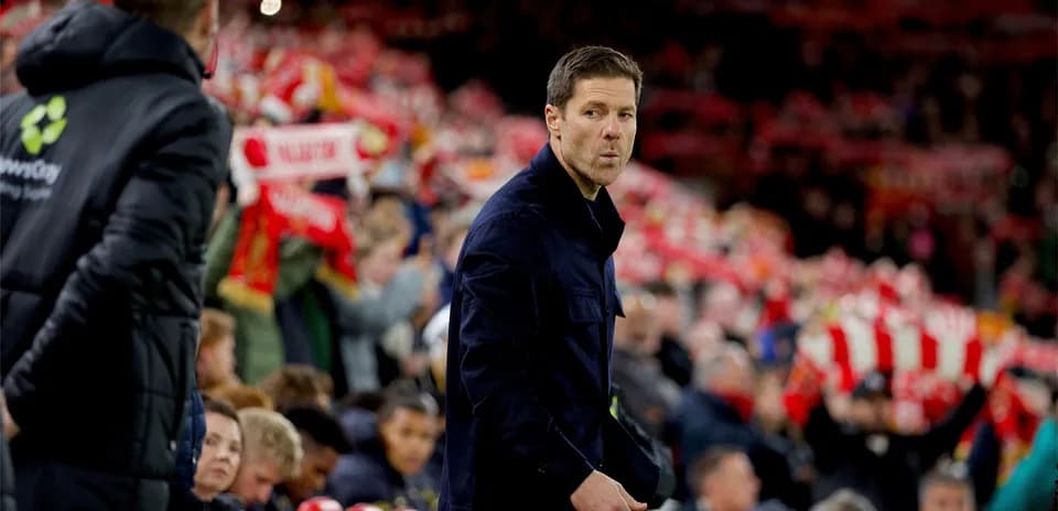 Entrenador caminando junto a aficionados con bufandas