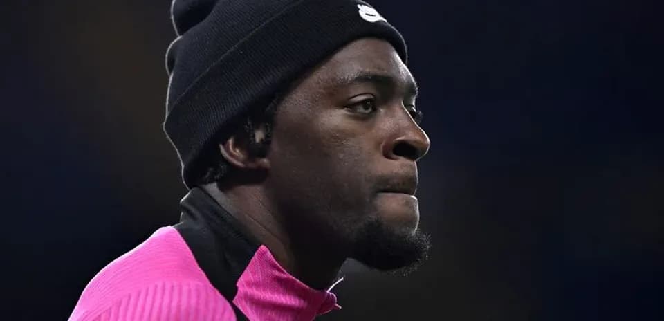 Jugador con gorro negro y camiseta rosa en la cancha