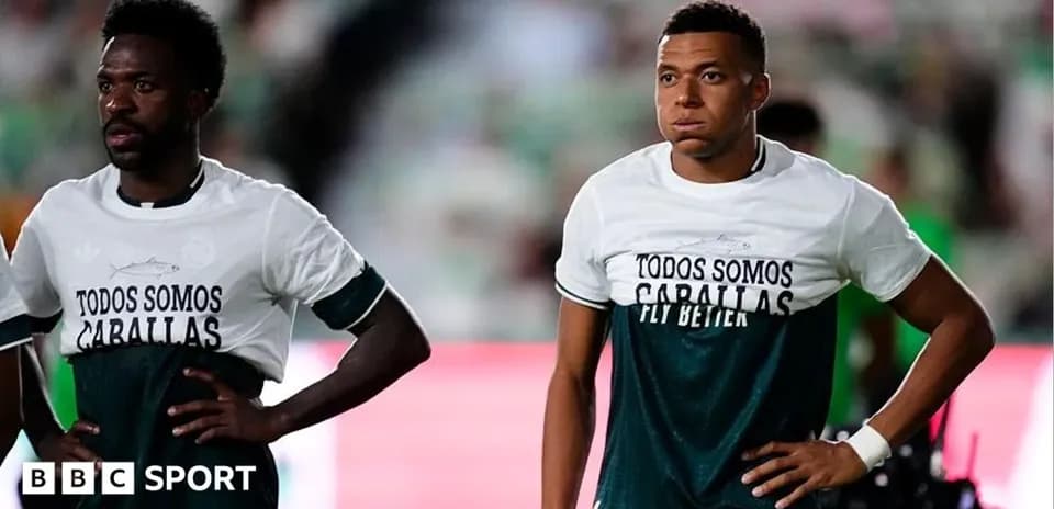 Jugadores en calentamiento con camisetas de apoyo