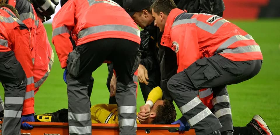 Equipo médico atendiendo a jugador lesionado en campo