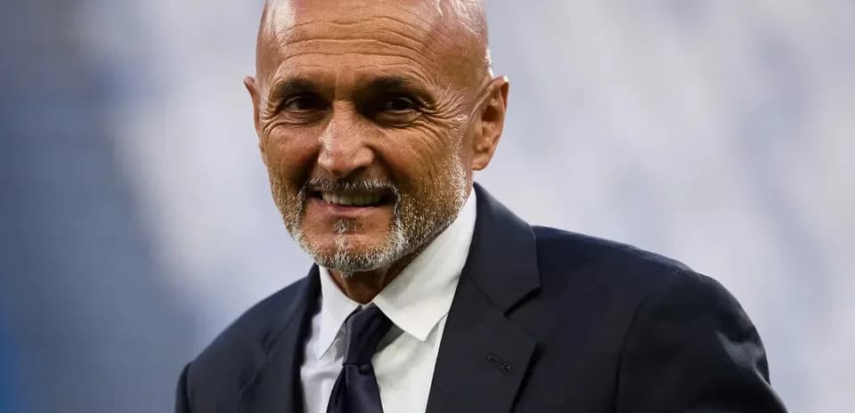 Entrenador sonriendo en el campo de fútbol
