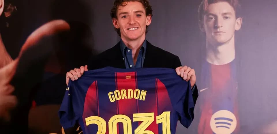 Jugador sosteniendo camiseta de FC Barcelona con nombre