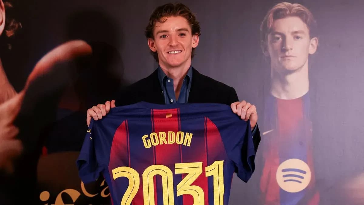 Jugador sosteniendo camiseta de FC Barcelona con nombre
