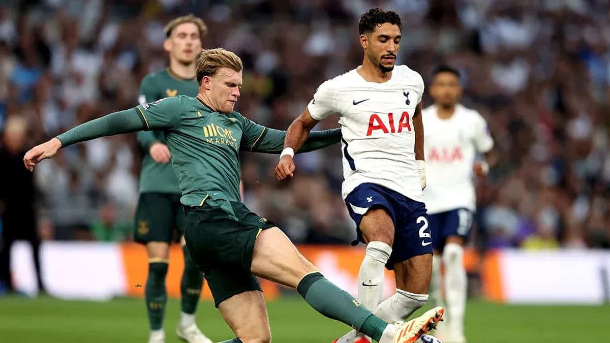 Jugador de Tottenham driblando mientras es tackleado