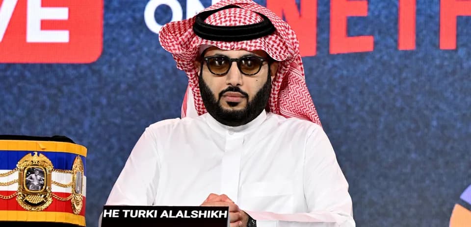 Hombre con gafas y keffiyeh en conferencia de prensa