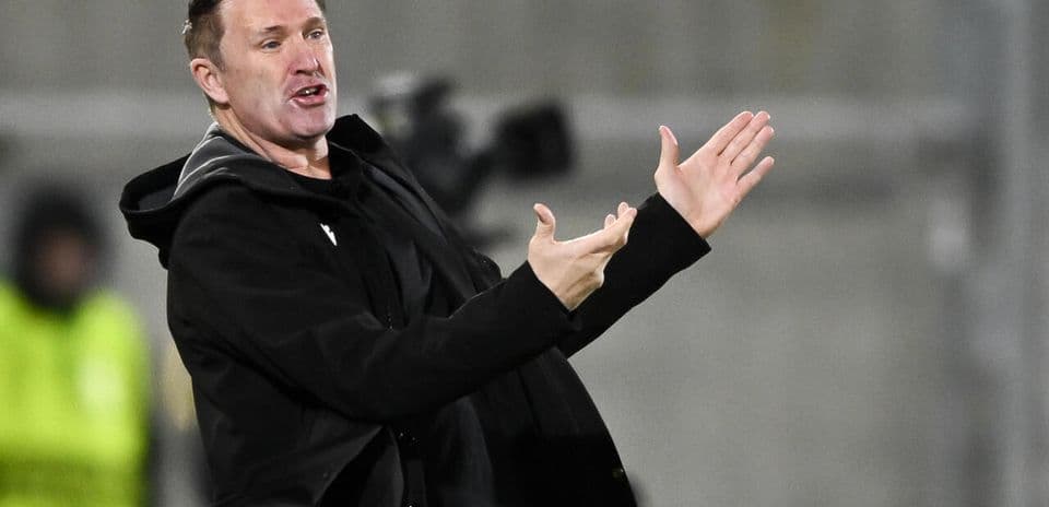 Entrenador gesticulando durante un partido de fútbol