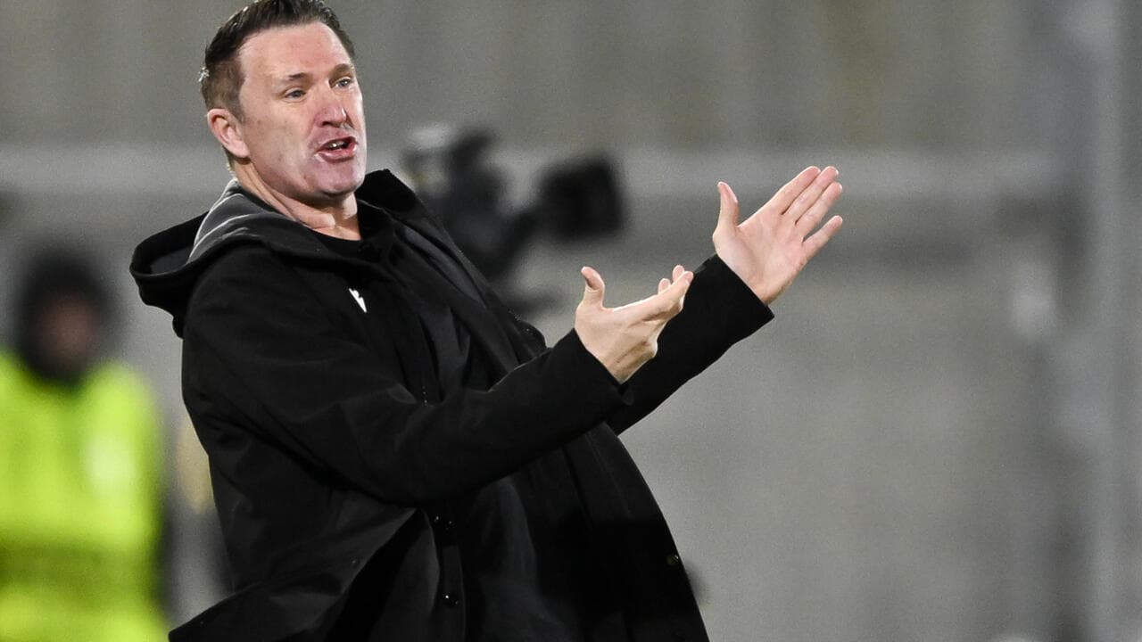 Entrenador gesticulando durante un partido de fútbol