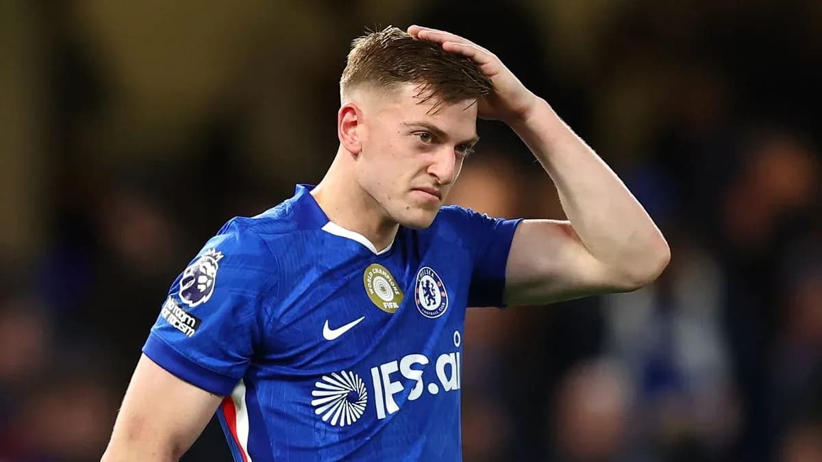 Jugador de Chelsea con camiseta azul tocándose la cabeza