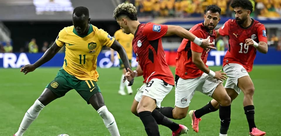 Jugador australiano driblando a oponentes egipcios en partido