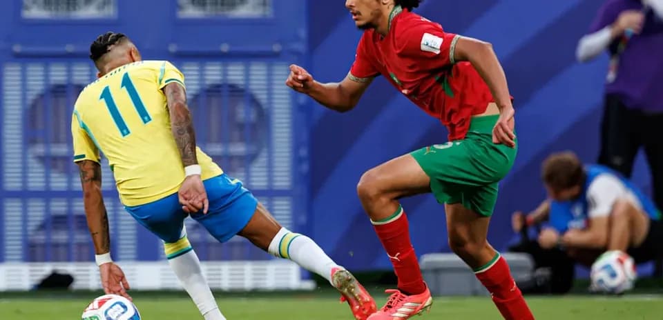 Jugador brasileño con balón, mientras es perseguido