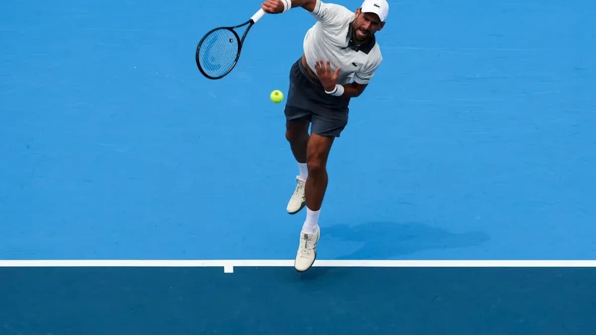Jugador de tenis realizando un saque en la cancha