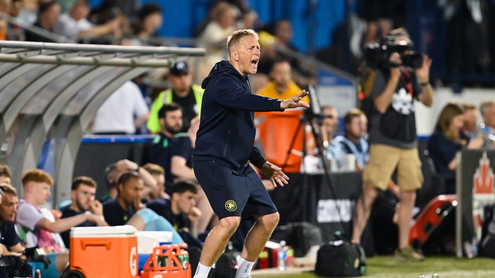 Entrenador dirigiendo a su equipo desde la línea lateral