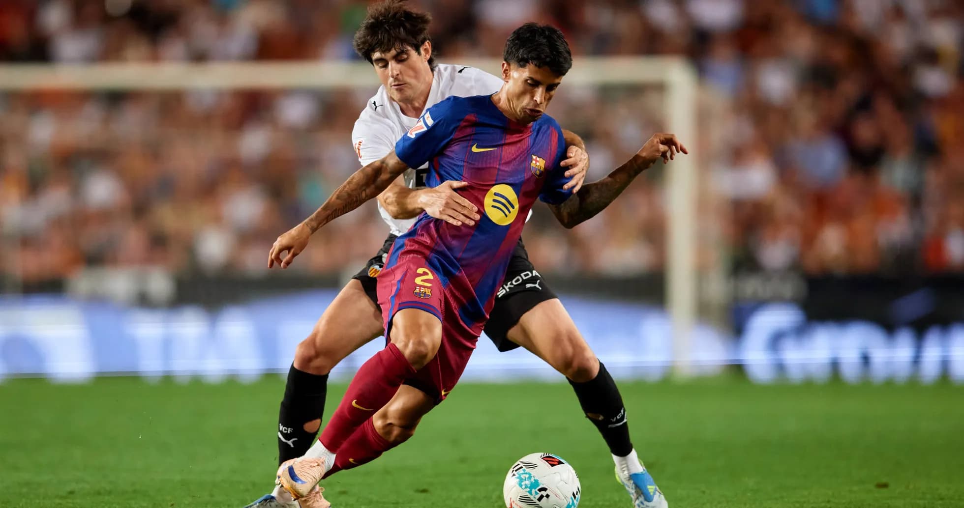 Jugador de Barcelona luchando por el balón contra rival
