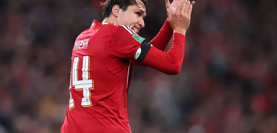 Jugador aplaudiendo con camiseta roja en estadio