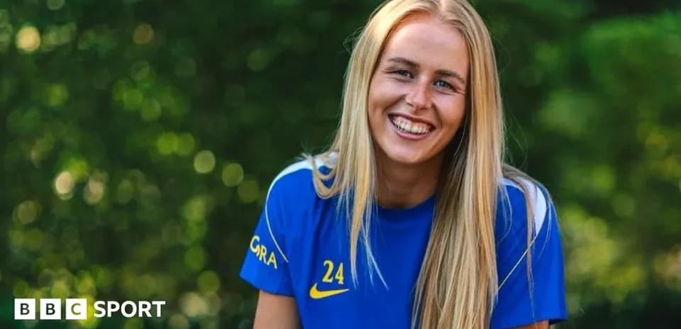 Jugadora sonriendo con camiseta azul en exterior