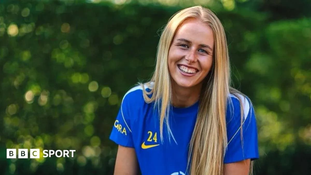 Jugadora sonriendo con camiseta azul en exterior