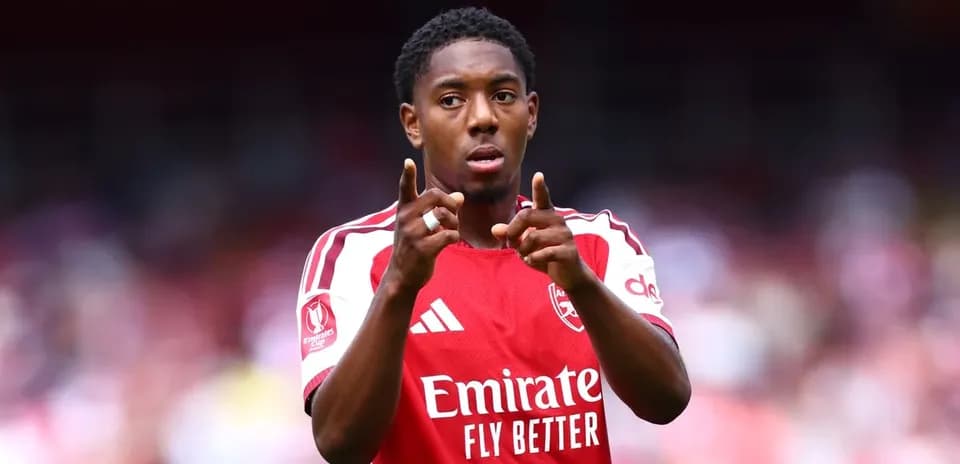 Jugador señalando durante partido con camiseta del Arsenal