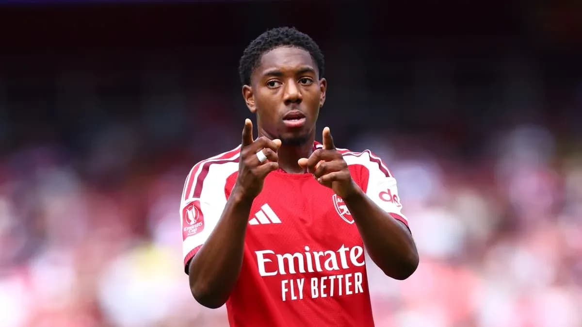 Jugador señalando durante partido con camiseta del Arsenal
