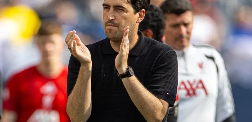 Entrenador aplaudiendo en el campo durante partido