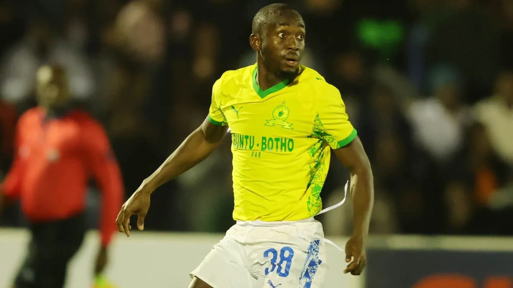 Jugador corriendo en camiseta amarilla de Mamelodi Sundowns