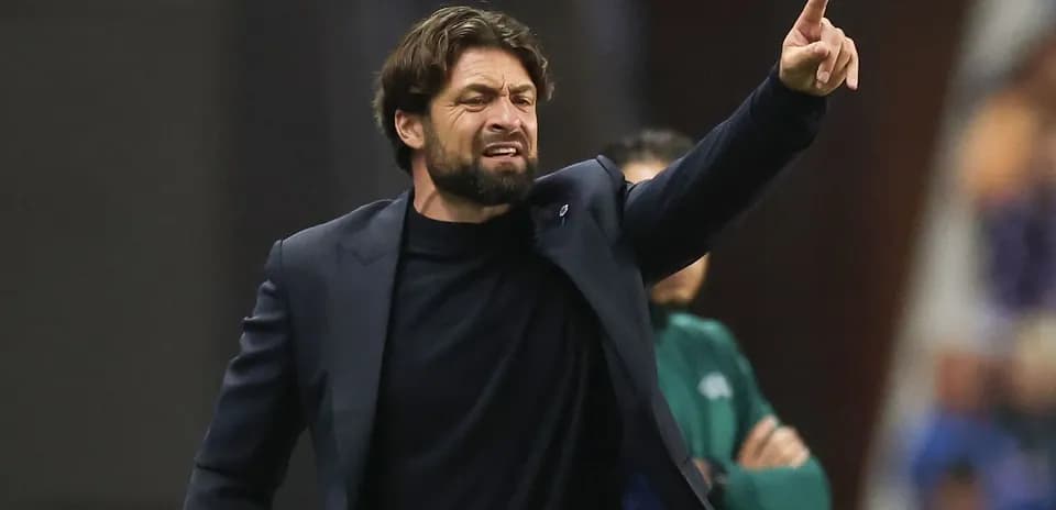 Entrenador dirigiendo al equipo desde la banda