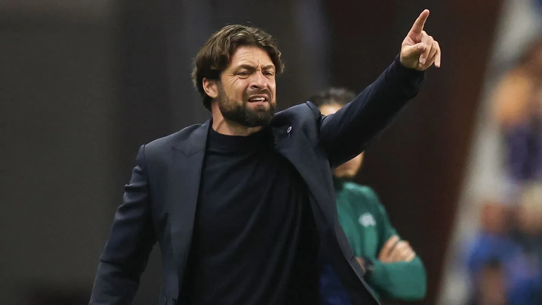 Entrenador dirigiendo al equipo desde la banda