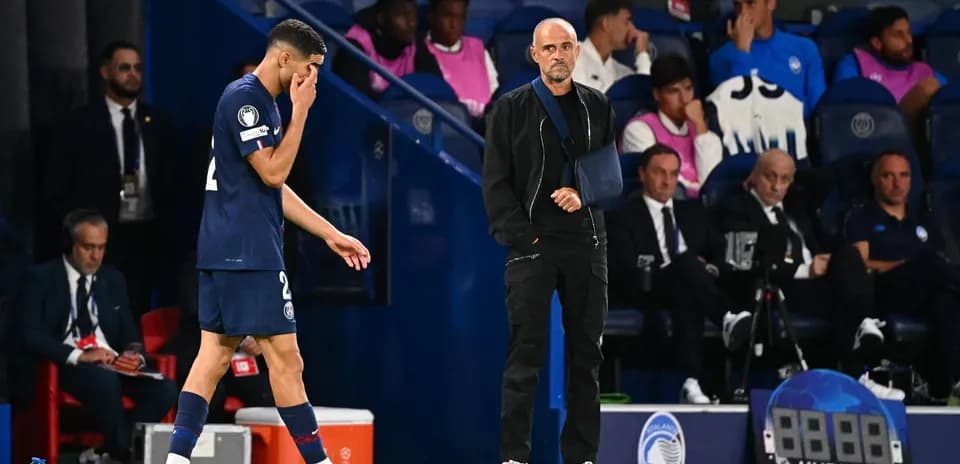 Jugador de PSG saliendo del campo con entrenador observando
