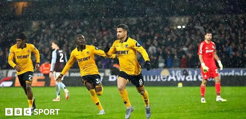 Jugador celebrando gol en partido de fútbol bajo la lluvia