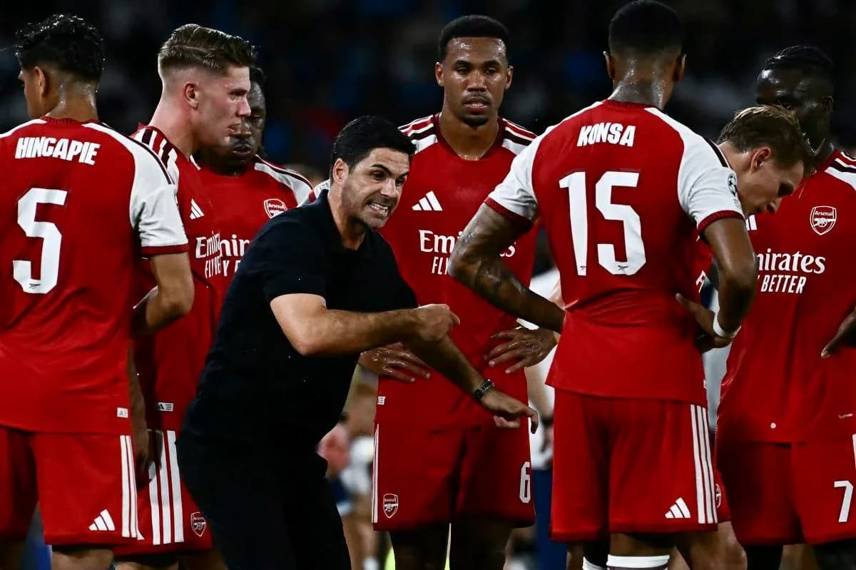 Entrenador dando instrucciones a jugadores de Arsenal