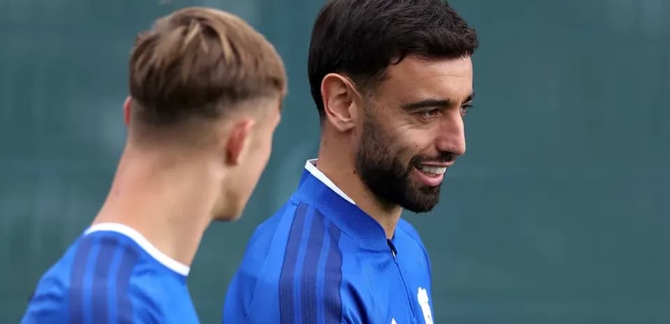 Dos jugadores conversando durante entrenamiento en campo