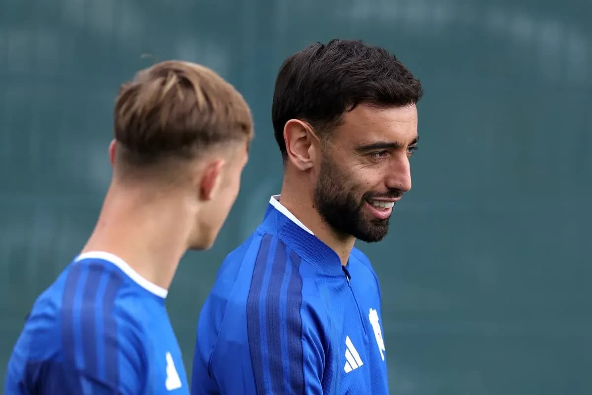 Dos jugadores conversando durante entrenamiento en campo