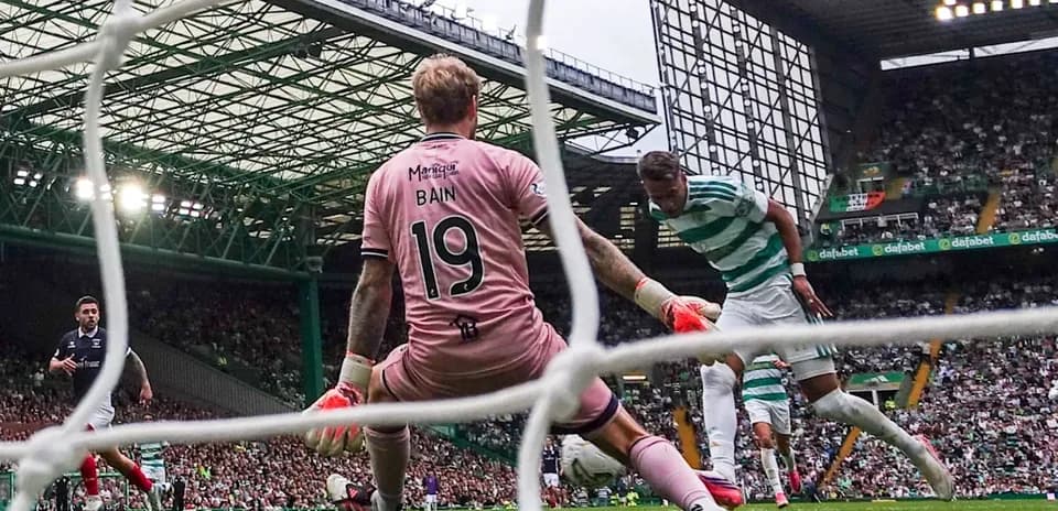 Jugador de Celtic intentando anotar contra el portero Bain