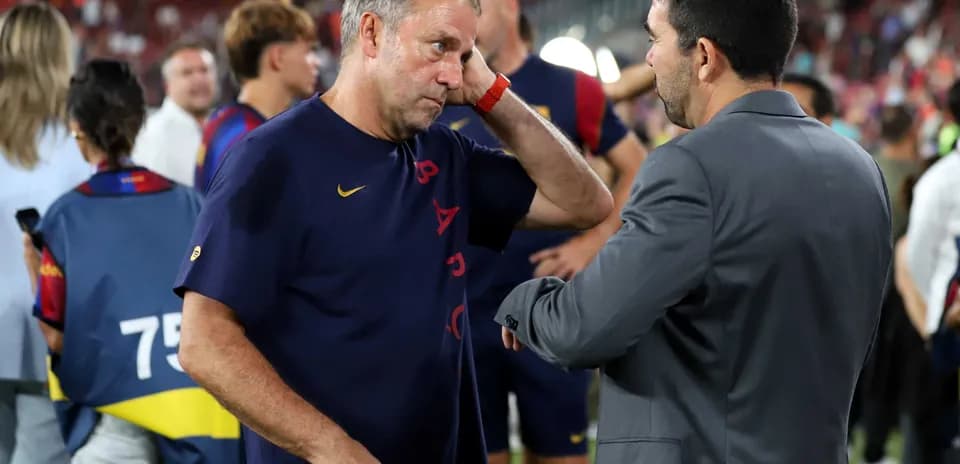 Entrenador conversando con otro en el campo