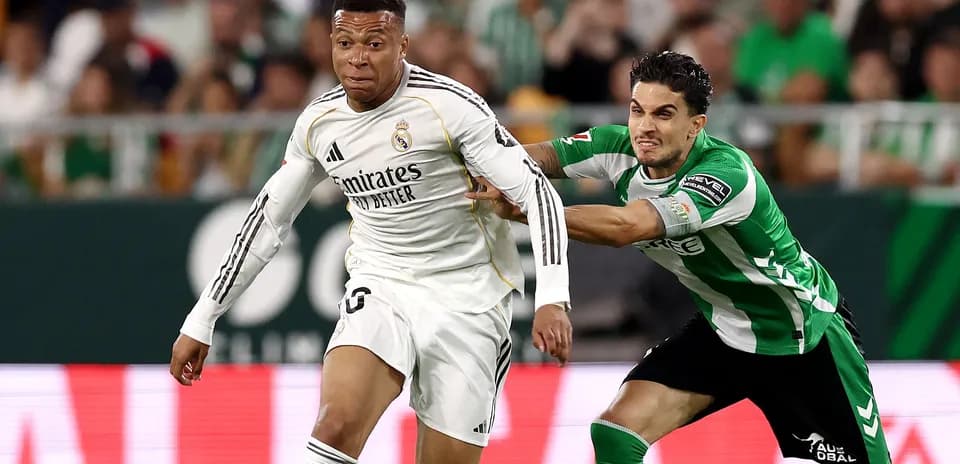 Jugador de Real Madrid corriendo con el balón, siendo marcado