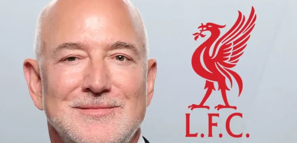 Hombre sonriendo con logo de Liverpool en fondo