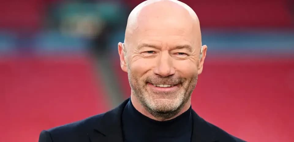 Hombre con traje sonriendo en un estadio