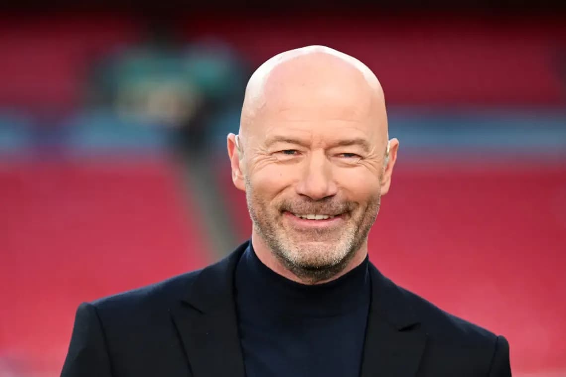 Hombre con traje sonriendo en un estadio