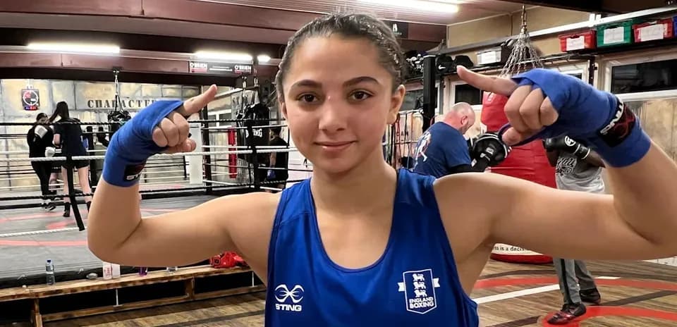 Boxeadora en el gimnasio mostrando señal de victoria