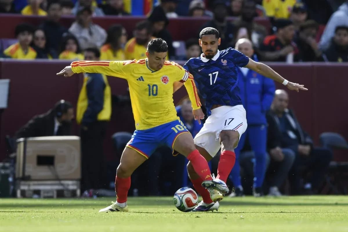 Jugador de Colombia intenta driblar a jugador francés