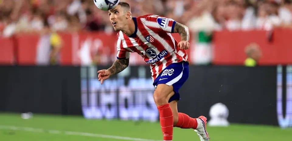 Jugador de Atlético de Madrid cabeceando el balón en el campo